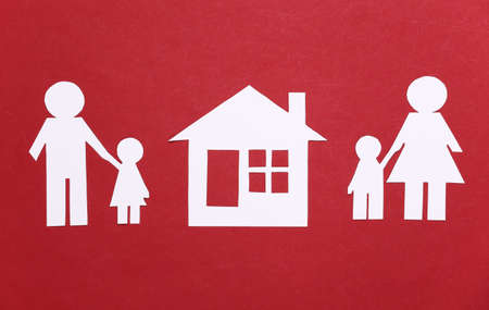 Broken family, divorce. Property division. Split paper family, house on a red backgroundの写真素材