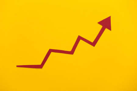 Red growth arrow on yellow background. Arrow graph going up. The economic growthの写真素材
