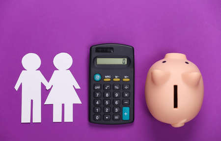 Calculation of the family budget concept. Paper couple in love together, calculator and piggy bank on purple background.の写真素材