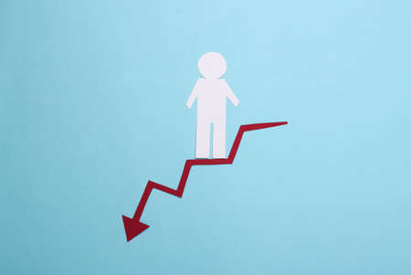 Paper man descends along a red curved arrow tending downward. Blue background. Symbol of financial and social degradation, stairway to recourseの写真素材