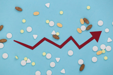 Pills with arrow tending up on a blue background. Top viewの写真素材