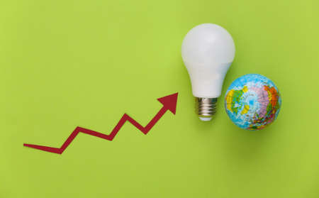 The symbol of modernization power consumption. Eco, save the energy. Globe and modern light bulb with growth arrow on green backgroundの写真素材