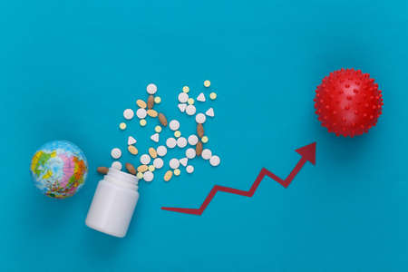 Pills, globe and model of virus strain with growth arrow tending upwards on blue background.の写真素材