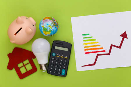 The symbol of modernization power consumption. Eco, save the energy, money. Energy class and light bulb, calculator, piggy bank with growth arrowの写真素材