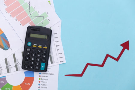 Growth upward arrow, graphs and charts and calculator on blue background. Business success. Top view