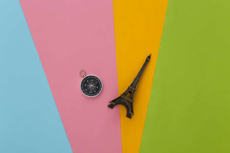 Compass and eiffel tower figurine on colored background. Travel, adventure flat lay. top viewの写真素材