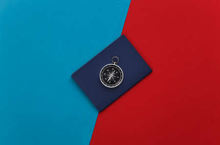 Compass and passport on a red-blue background. Travel, adventure flat lay. top viewの写真素材