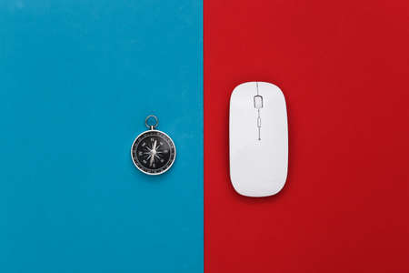 Compass and pc mouse on a red-blue background. Travel or online business concept. top viewの写真素材