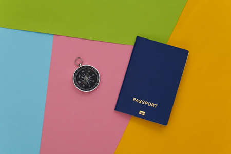 Compass and passport on colored background. Travel, adventure flat lay. top view