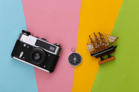 Compass, ship and camera on colored background. Travel, adventure flat lay. top viewの写真素材