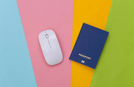 White pc mouse and passport on colored background. top view. flat layの写真素材