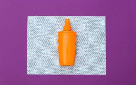 beach holidays. Sunblock bottle, starfish on blue purple background. top view. flat lay