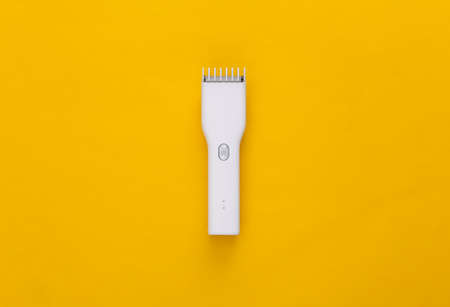 Wireless hair clipper on yellow background. top viewの写真素材