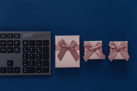 PC keyboard with gift boxes on a classic blue background. top viewの写真素材
