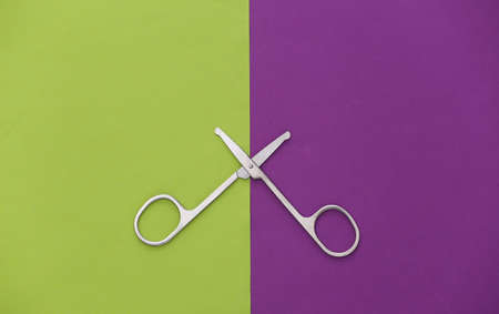 Manicure scissors on purple green background. beauty concept. nail care. top view