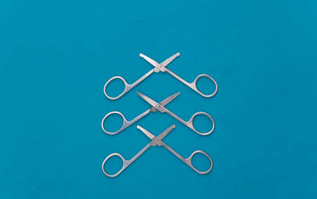 Three Manicure scissors on blue background. beauty concept. nail care. top viewの写真素材