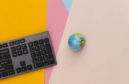 global web. PC keyboard with globe on colored background. top viewの写真素材