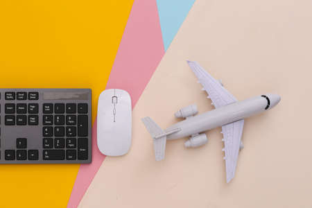 travel concept. PC keyboard and air plane on colored background. top viewの写真素材