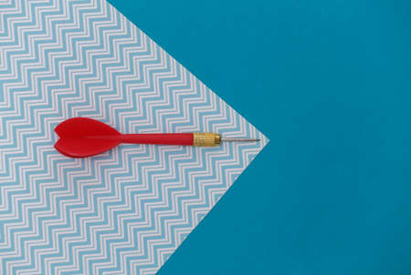 Red plastic dart with metal tip on blue pastel background with copy space. top view. flat lay. minimalismの写真素材