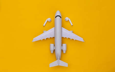 Air Plane and wireless headphones on yellow background. top viewの写真素材