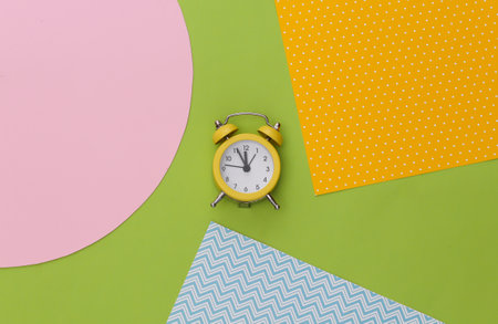 Yellow retro alarm clock on creative colorful paper background. top view. minimalismの写真素材