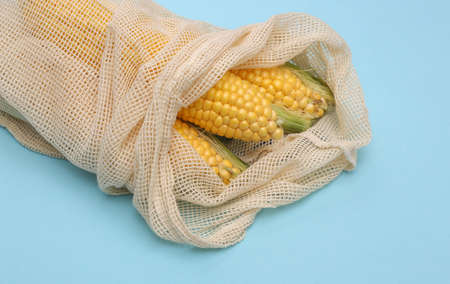 Corn swings in eco cotton bag on blue background close upの写真素材
