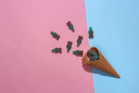 Ice cream waffle cone with gummy candy on bright pink blue background with deep shadow, Top viewの写真素材