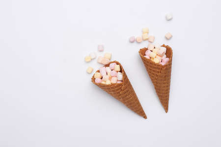 Ice cream waffle cones with marshmallows on white backgroundの写真素材