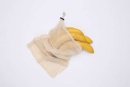 Eco cotton bag with ripe bananas on white backgroundの写真素材