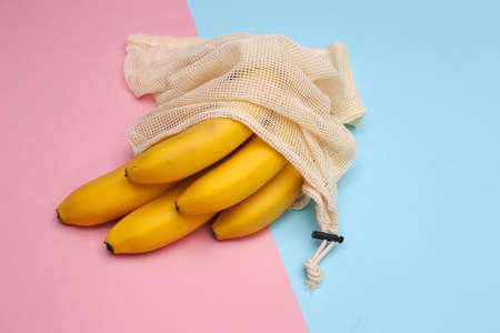 Eco cotton bag with ripe bananas on pink blue pastel backgroundの写真素材