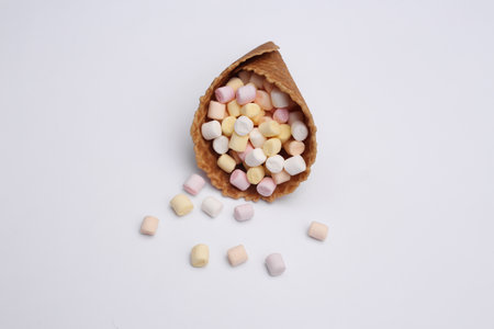 Ice cream waffle cone with marshmallows on white backgroundの写真素材
