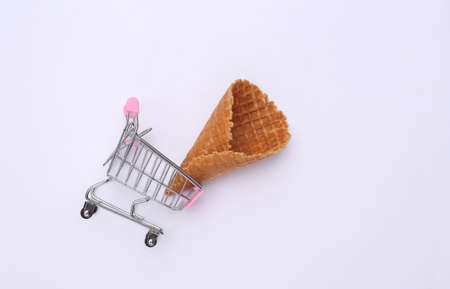 Shopping trolley with Ice cream waffle cone on white background. top viewの写真素材