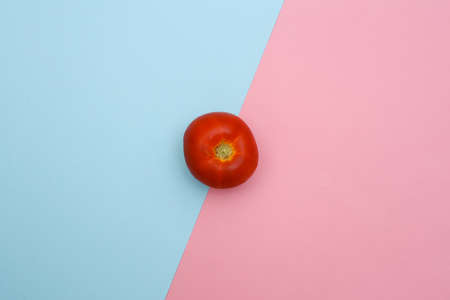 Red Tomato on blue pink pastel background. Minimalist food flat lay. top viewの写真素材