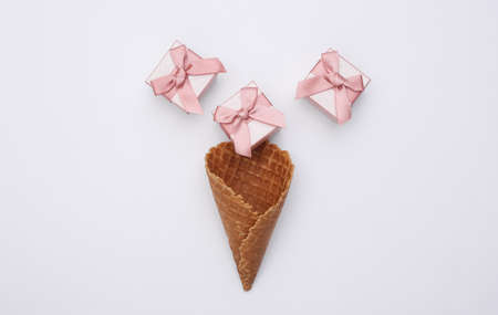 Ice cream waffle cone with gift boxes on white background. top viewの写真素材