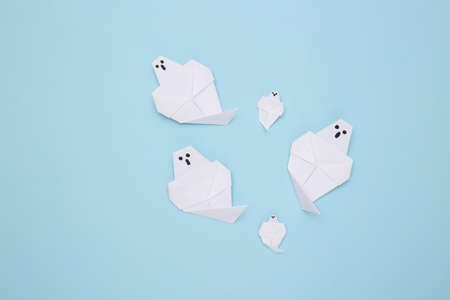 Origami ghosts on a blue background. handmade halloween decor. top viewの写真素材