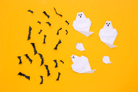 Paper Flying bats, ghosts on yellow background. Halloween handmade background. top view. flat layの写真素材