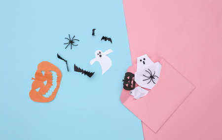 Envelope with handmade Halloween paper decor on pink blue pastel background. Halloween background. top viewの写真素材