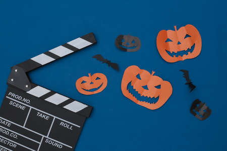 Movie Clapperboard, Paper cut Flying bats and halloween pumpkin on classic blue background. Halloween horror movie. top viewの写真素材