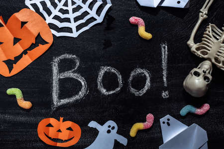 Chalk Lettering Boo! on a chalk board with Handmade Halloween decor and skeleton, gummy worms. Halloween themeの写真素材