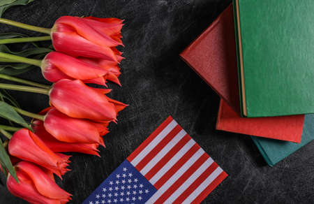 national holiday. Bouquet of tulips, books and USA flag on a chalk board. back to school. knowledge dayの写真素材