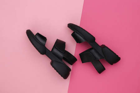 Leather black women's sandals on pink background. top view. flat lay