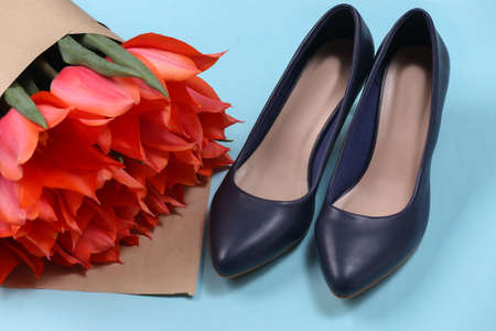 Bouquet of red tulips and high heel shoes on blue background. Holiday Mother's Day or March 8th, birthday.の写真素材