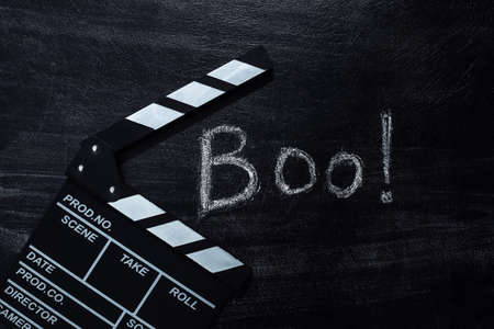 Movie Clapperboard and Chalk Lettering Boo! on a chalk board. Halloween themeの写真素材