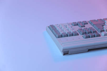 Old pc keyboard in pink blue gradient neon, holographic light.の写真素材