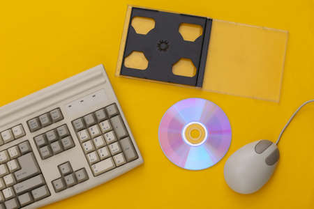 Retro electronics, pc technology 90s. PC keyboard, mouse, cd on a blue background. top viewの写真素材