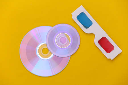 Compact disc with box, 3d glasses on yellow background. top viewの写真素材