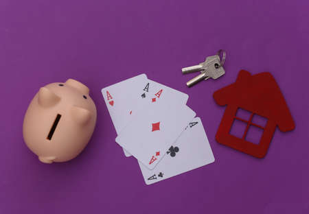 Everything at stake, win, winner. Four aces, house figure, key, piggy bank on a purple background. top viewの写真素材