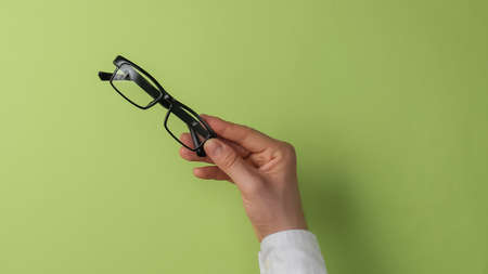 Male hands holding glasses on a green background. office worker. business. top view