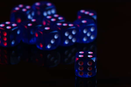 Dice on black background with red blue neon lightの写真素材