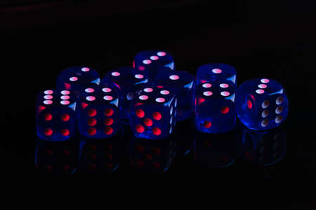 Dice on black background with red blue neon lightの写真素材